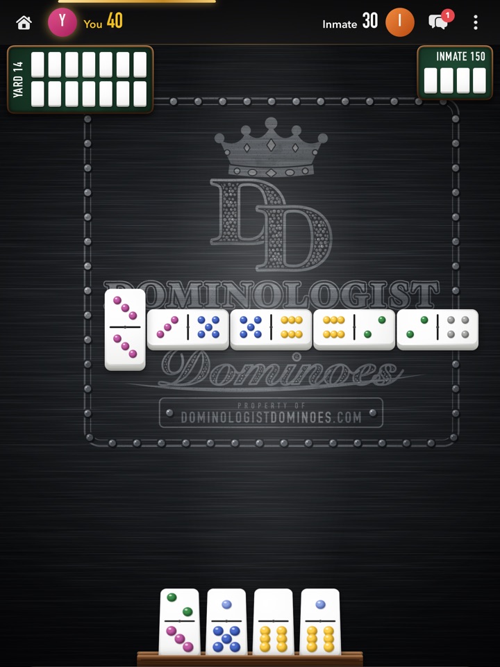 An Inmate game in progress on the black steel: bones played across the logo etched in a riveted plate, the PROPERTY OF dominologistdominoes.com tag, and your four bones in the rack.